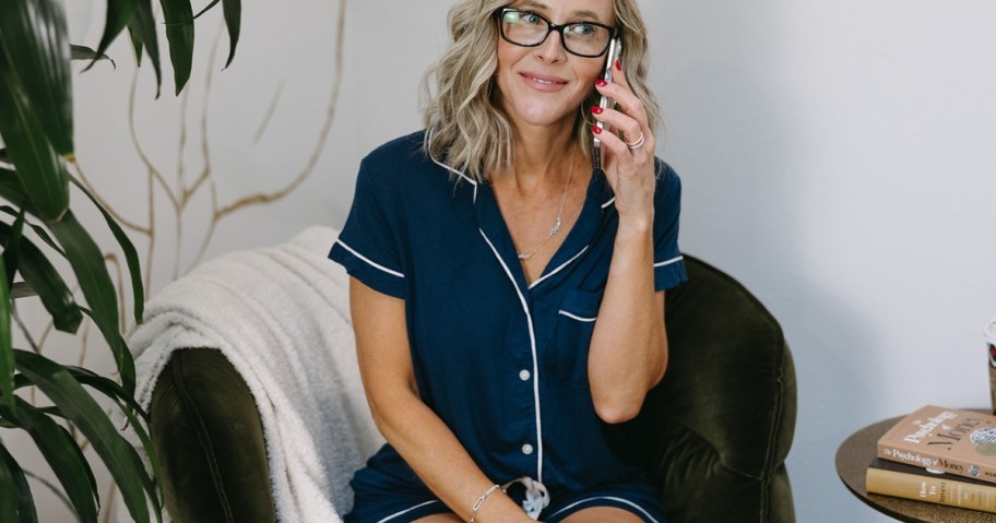 Collin holding a smartphone to her ear, wearing a set of blue notch collar button up pajamas