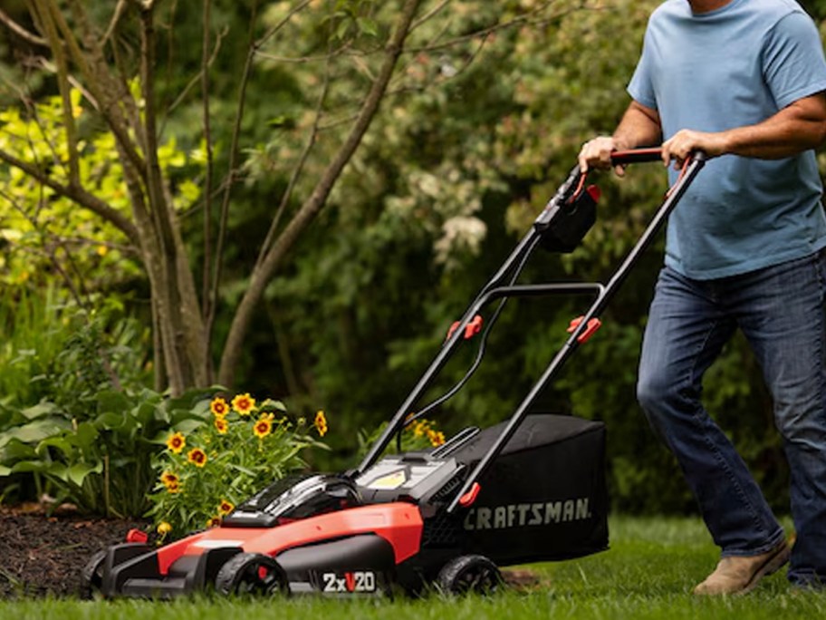 man pushing red and black craftsman mower 