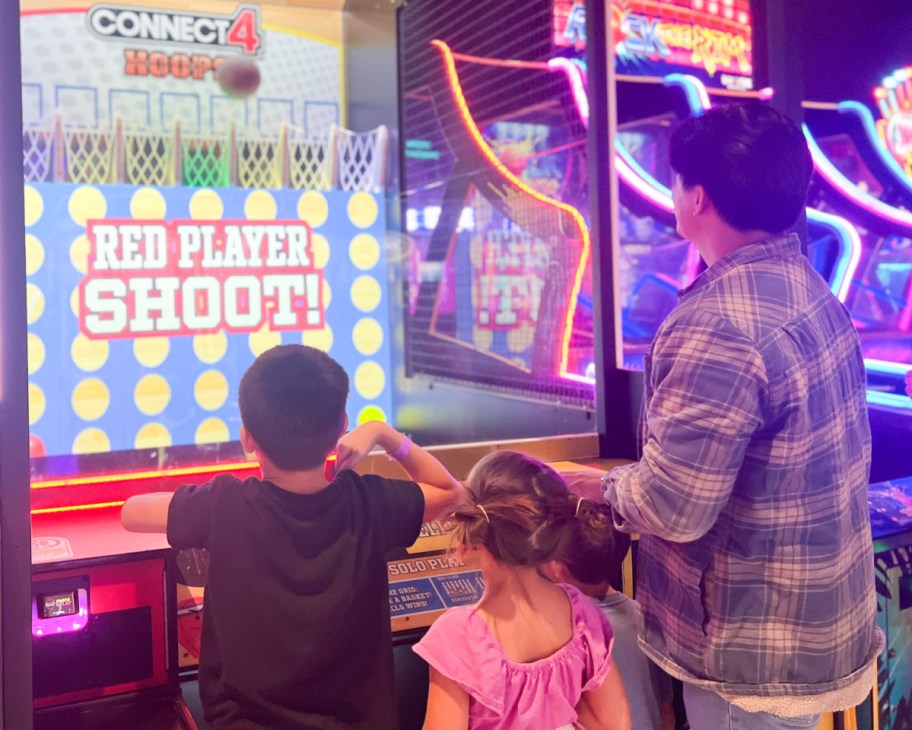 two kids and adult playing connect 4 hoops