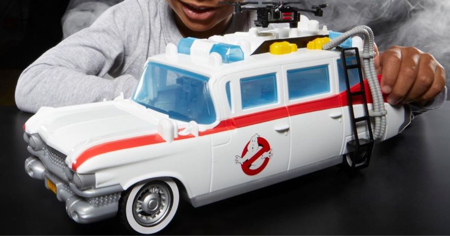 boy playing with Ghostbusters Track & Trap Ecto-1 Toy Vehicle with Fright Features Ecto-Stretch Tech Slimer Accessory, onlinepatible with 5-Inch Toys, 4+