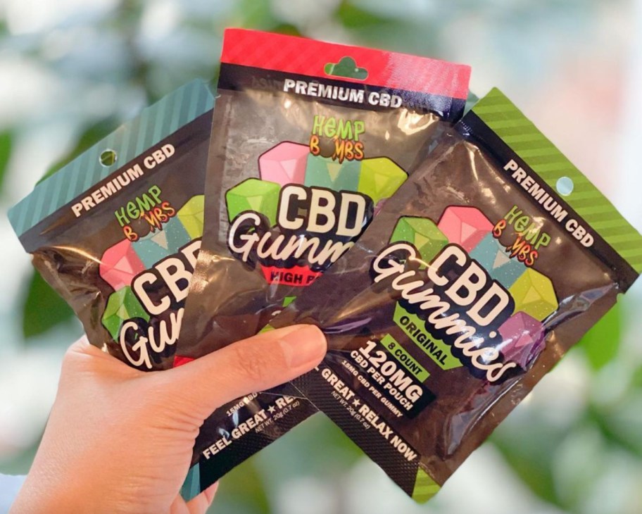 hand holding packs of CBD gummies