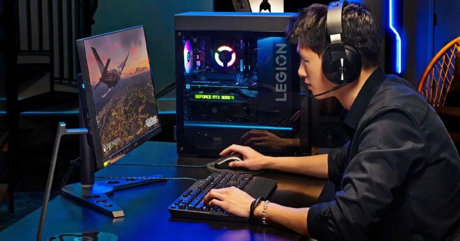 boy playing on gaming onlineputer with keyboard wearing headset