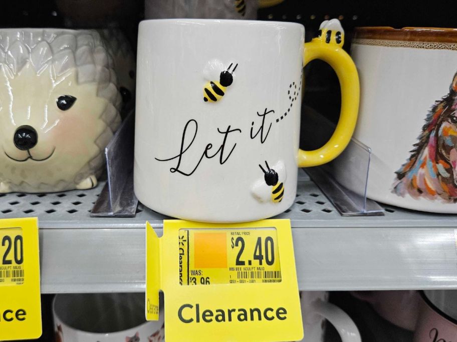 a white mug with bees on it and text "let it be"