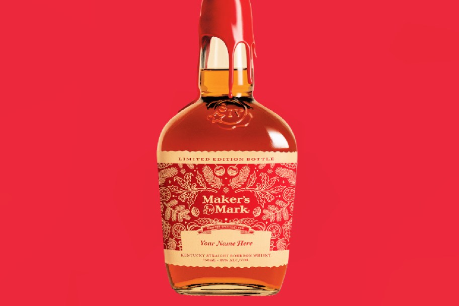 makers mark bottle with a holiday label against a red background