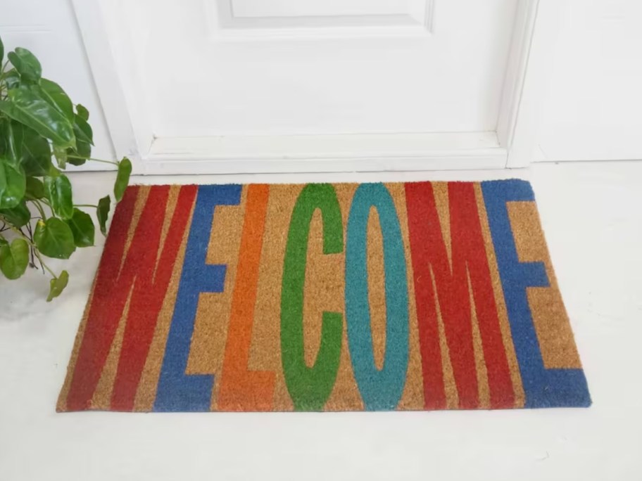 a coir doormat with the word "welonlinee" in colorful letters in front of a door