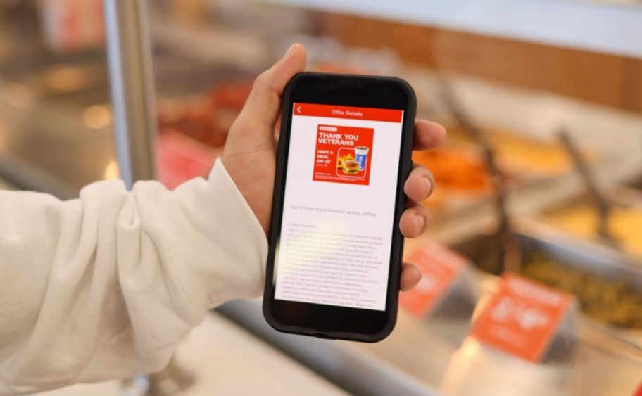 holding a phone open to the Pilot Flying J app