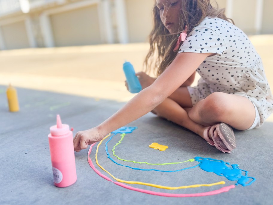 girl on sidewalk painting with puffy paint