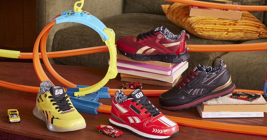 yellow, red, and black hot wheels shoes on table with hot wheels track 