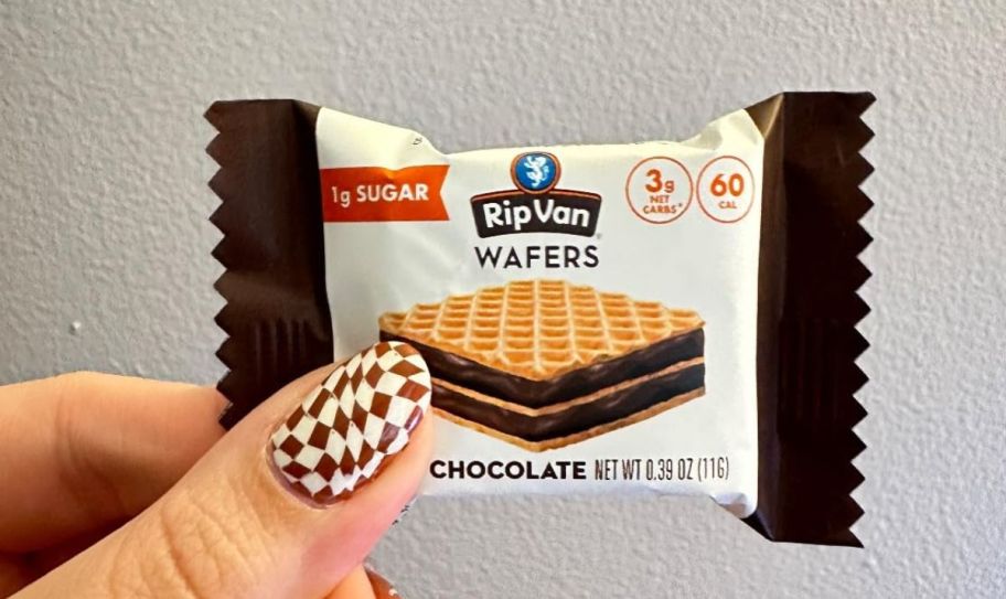 a womans hand holding a rip van dark chocolate mini wafer