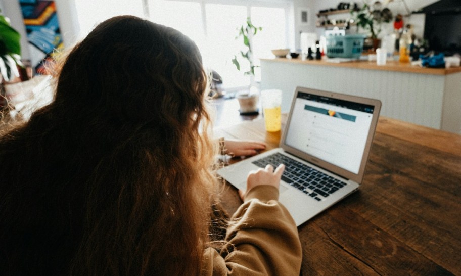 girl sitting at laptop in kitchen