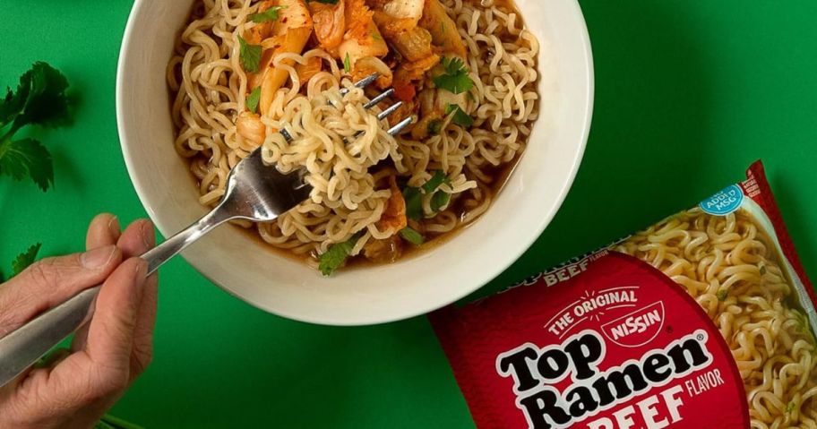 Nissin Top Ramen Noodle Soup in bowl with package sitting next to it on table