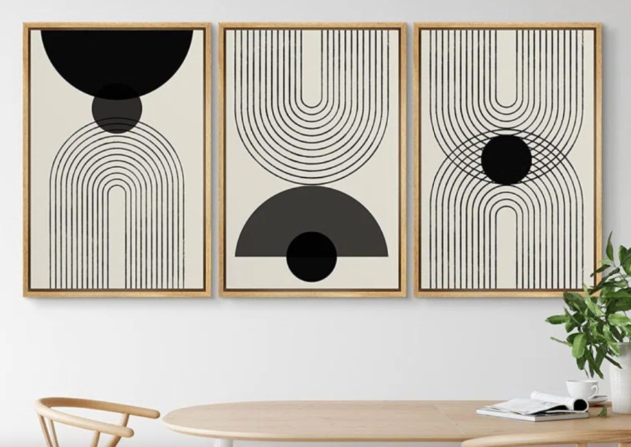 three modern black and white art prints in brown frame