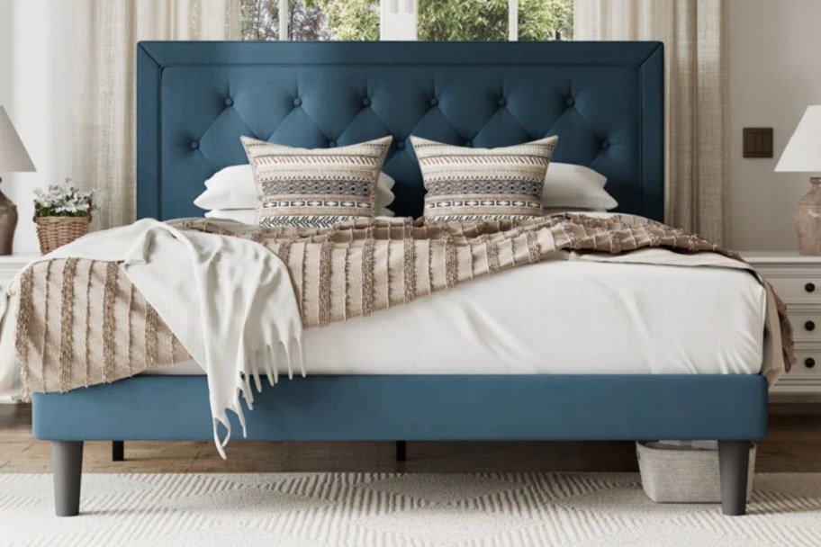 teal upholstered bed with pillows
