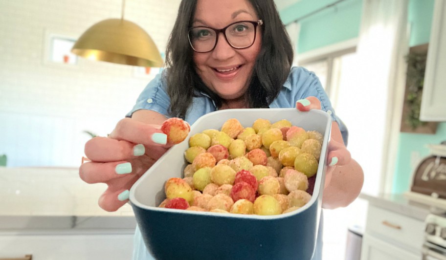 woman holding sour patch grapes in a container