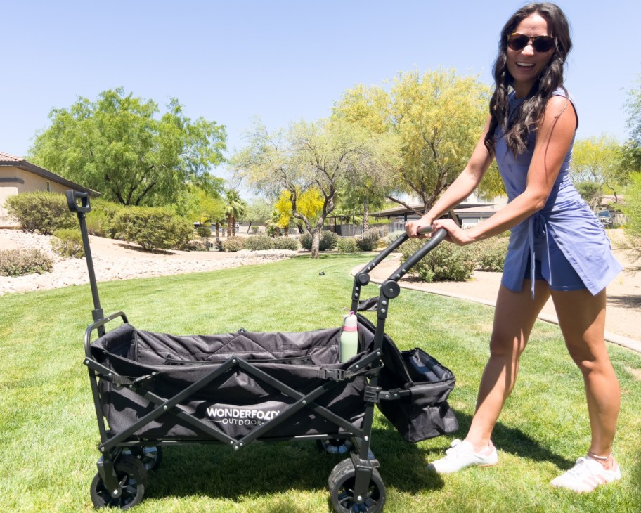 woman pushing wagon in grass