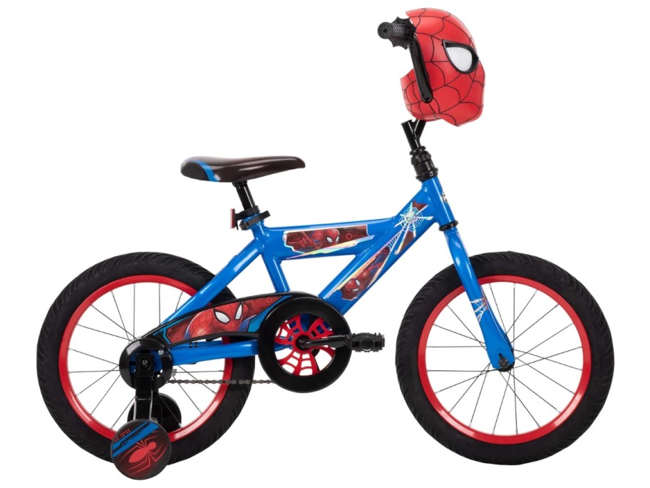 a kid's Spiderman bike with blue, red, and black details and a Spiderman face mask on the front handlebar