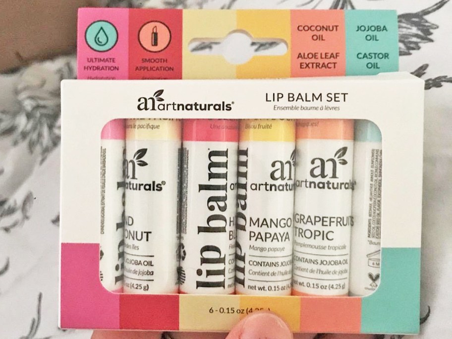 hand holding a set of ArtNaturals Organic Lip Balms