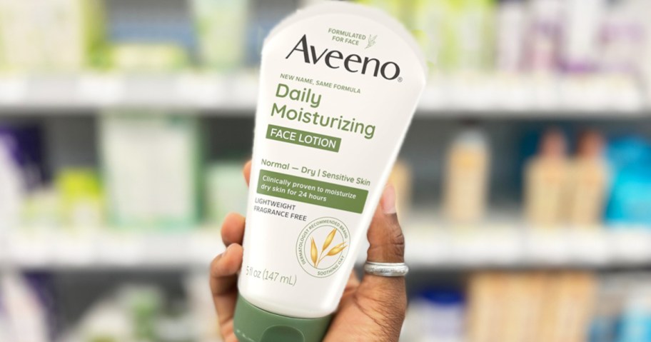 hand holding a bottle of aveeno face lotion in store