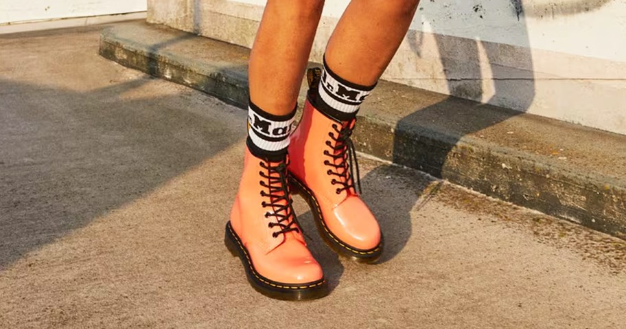 woman wearing coral colored patent leather boots