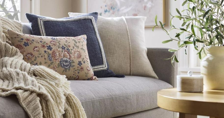 A beautifully decorated couch with throw pillows and a blanket