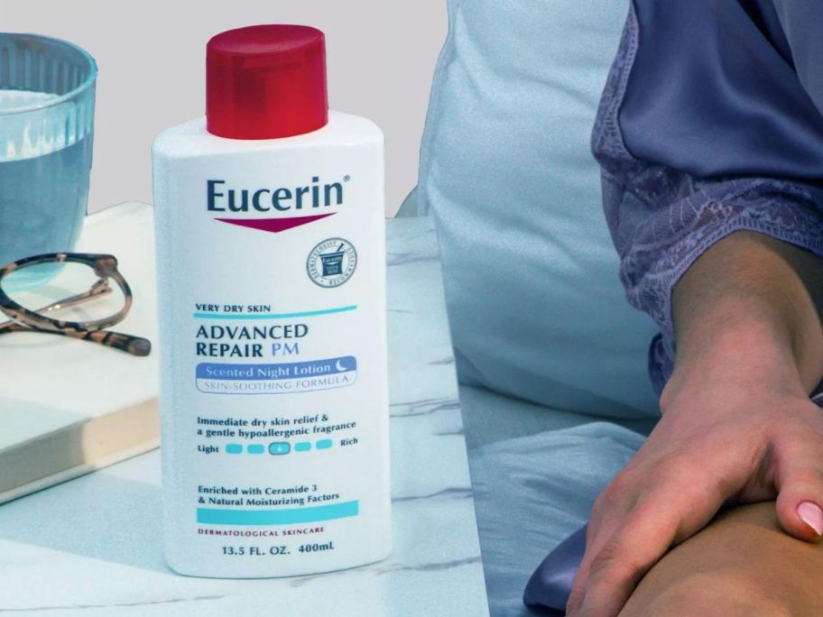 A bottle of Eucerin Advanced Repair Night Body Lotion on a side table