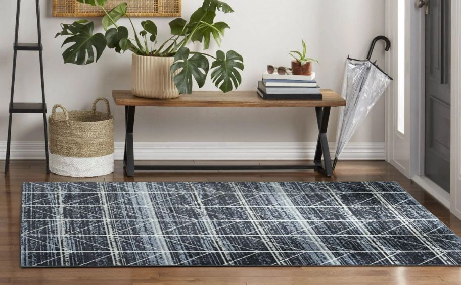 a navy blue geometric patterned rug on a hardwood floor 