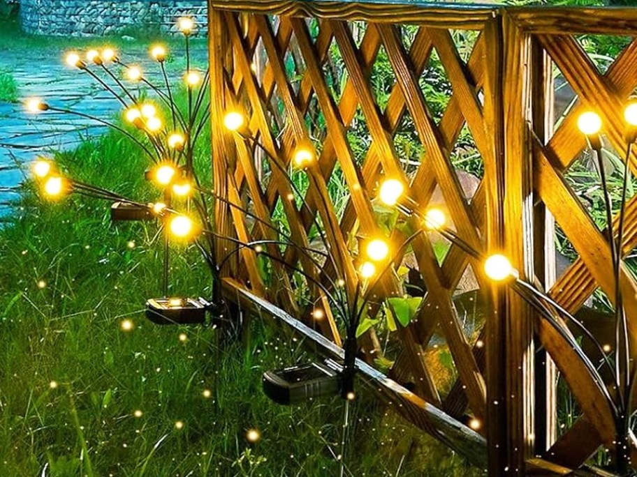 firefly solar stake lights lining fence in yard