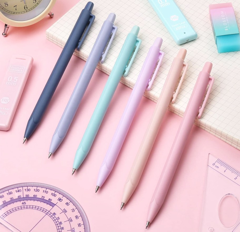 colorful mechanical pencils on stack of graph paper