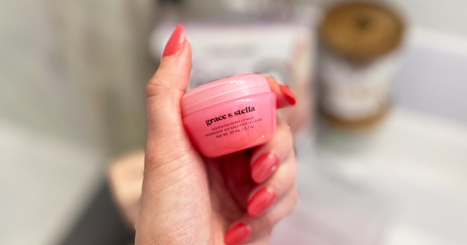 woman holding up pink jar of Grace & Stella Lip Mask