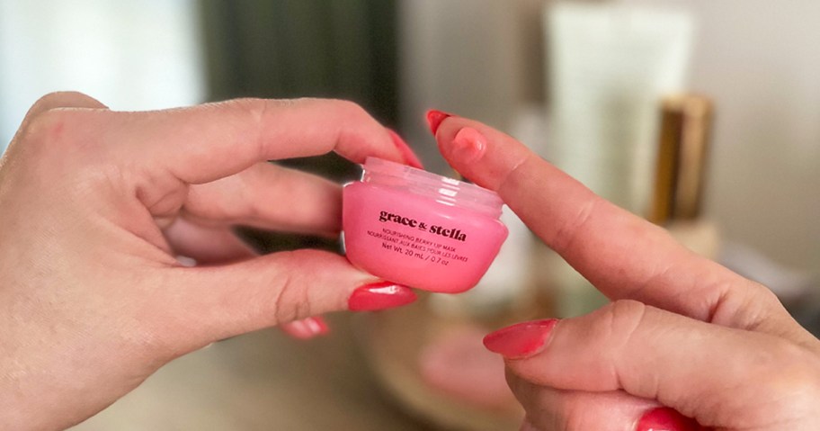 woman holding up pink jar of Grace & Stella Lip Mask