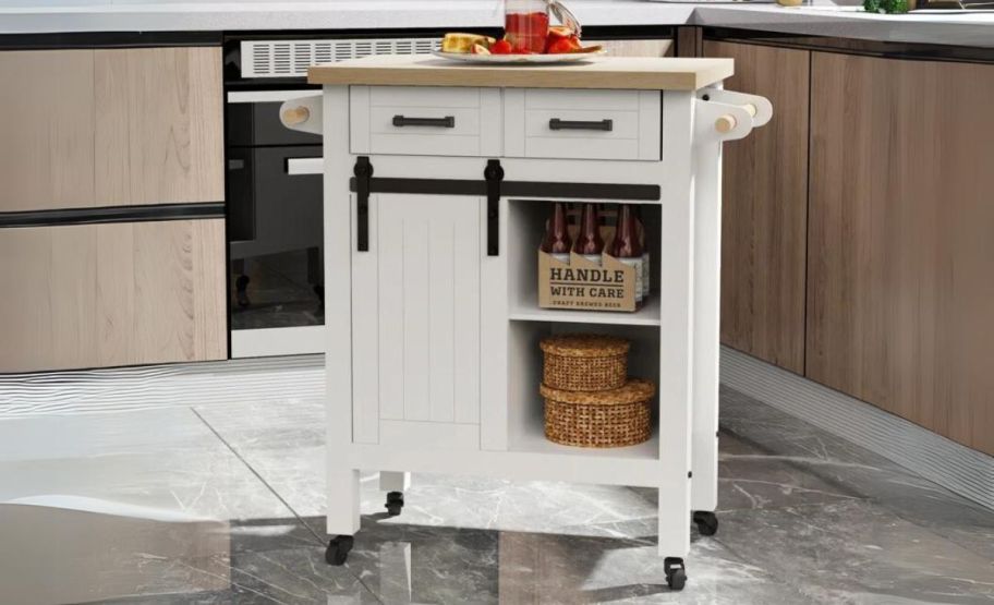 a white rolling kitchen cart shown with food items in a kitchen