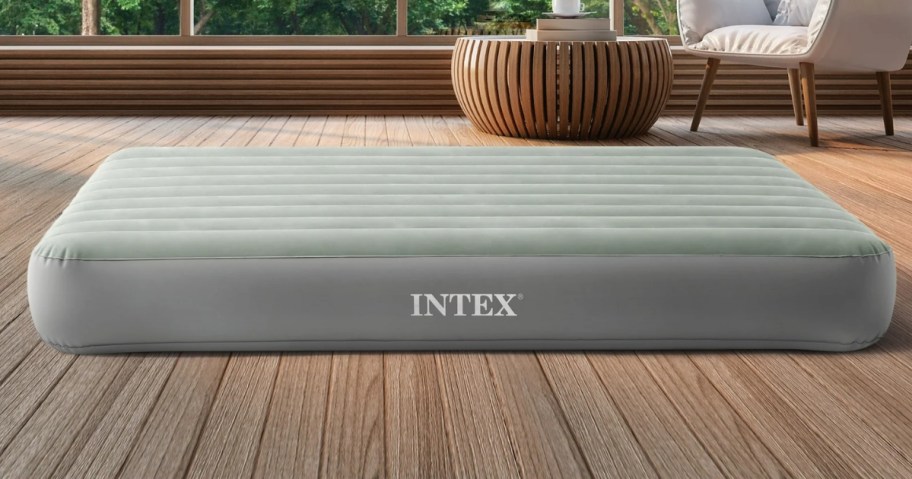 a light green large air mattress on a wooden floor