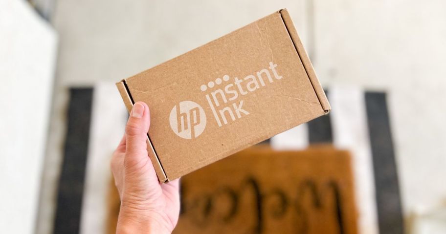 Woman Holding HP Instant Ink Box at her front door