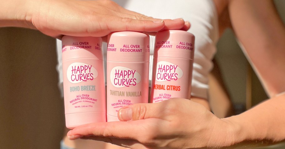 hands holding three happy curves deodorant sticks