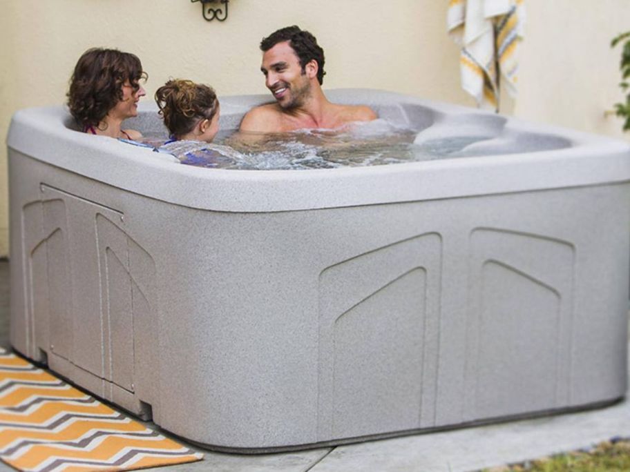 two adults and a child in a Lifesmart 4-Person Spa