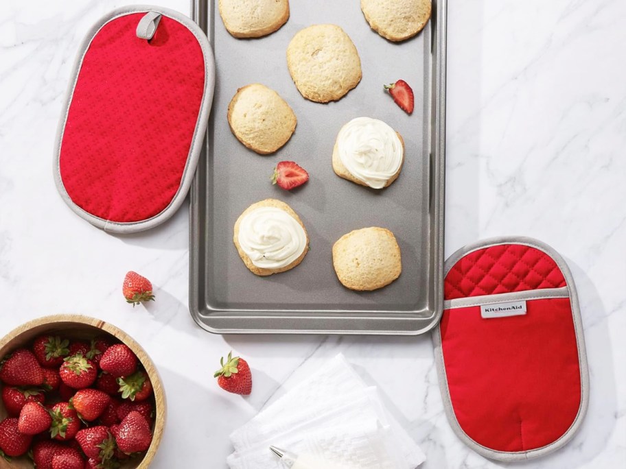 set of red pot holders on counter next to cookie sheet