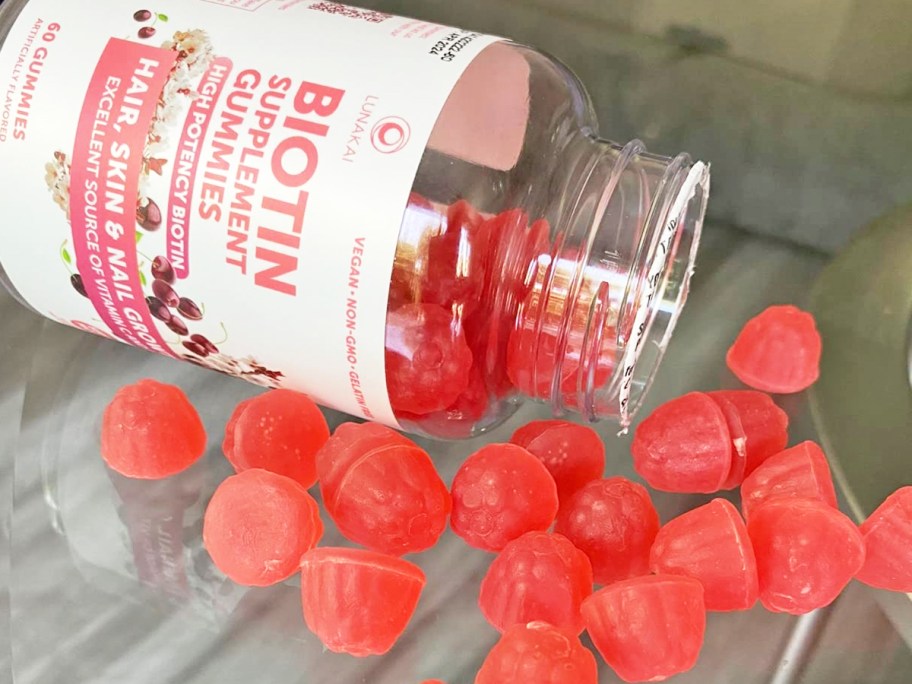 bottle spilling red gummies onto glass table