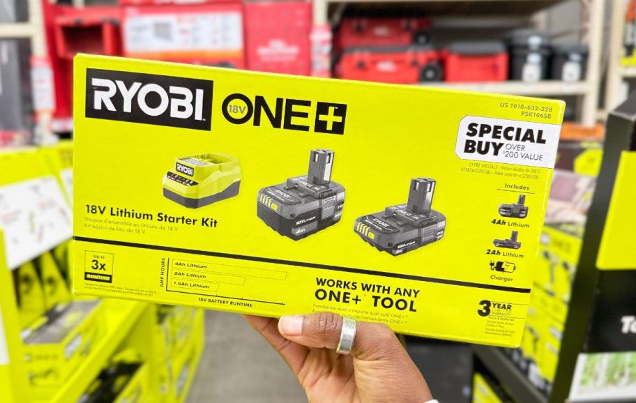 a womans hand holding a ryobi battery starter kit