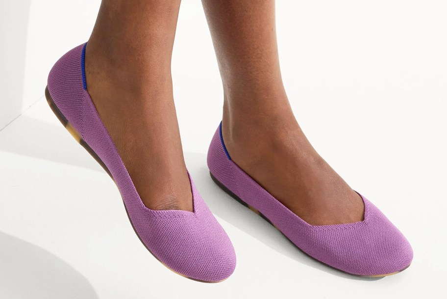 woman wearing pair of purple flats