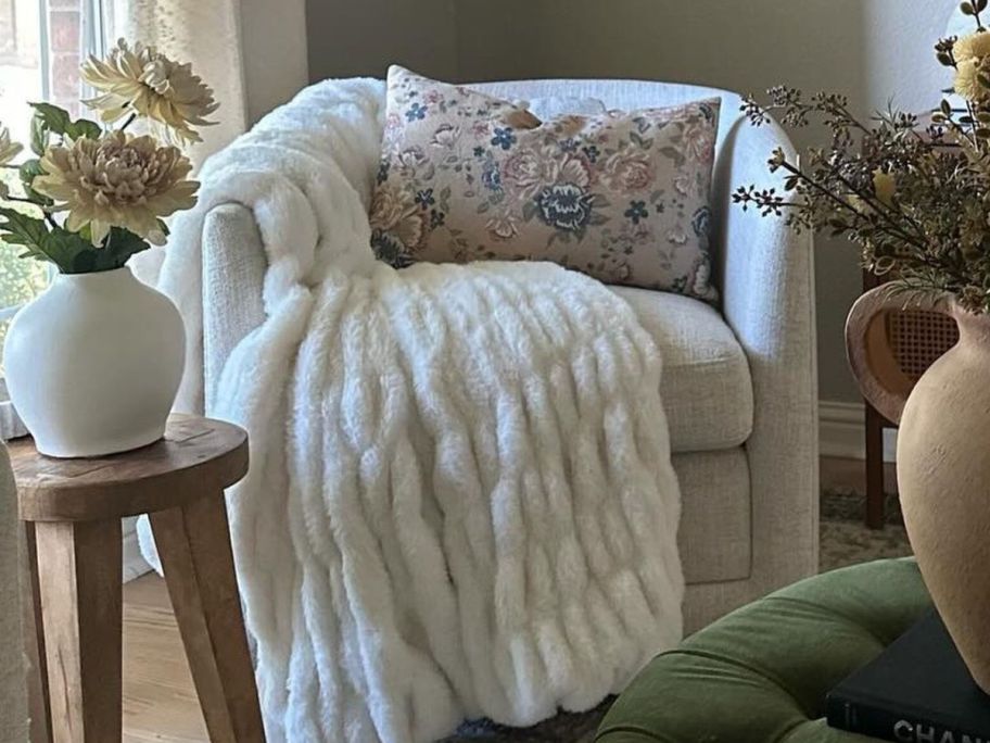 A Threshold Ruched Faux Rabbit Fur Throw Blanket on a chair 