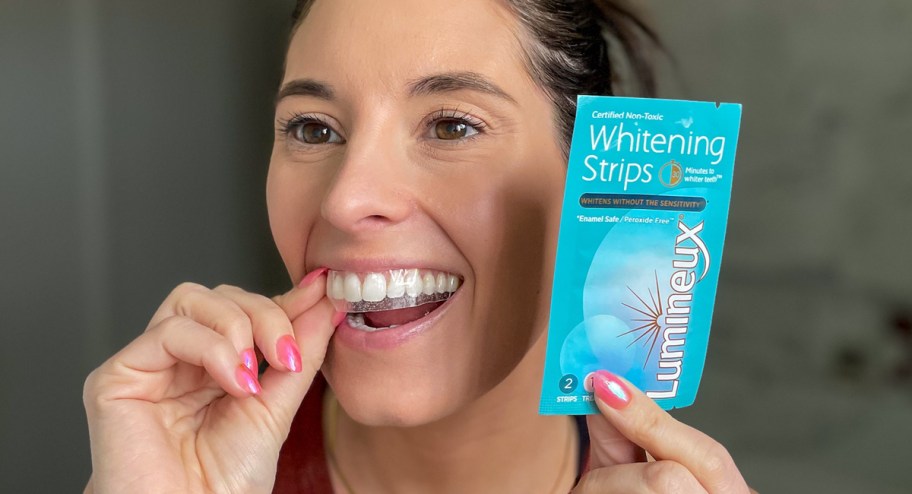 WOman using Luminex whitening strips and applying it to her teeth