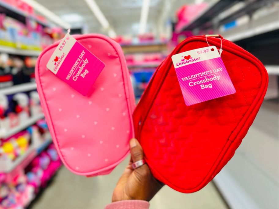 A person holding 2 Walmart Crossbody Bags in Pink and Red