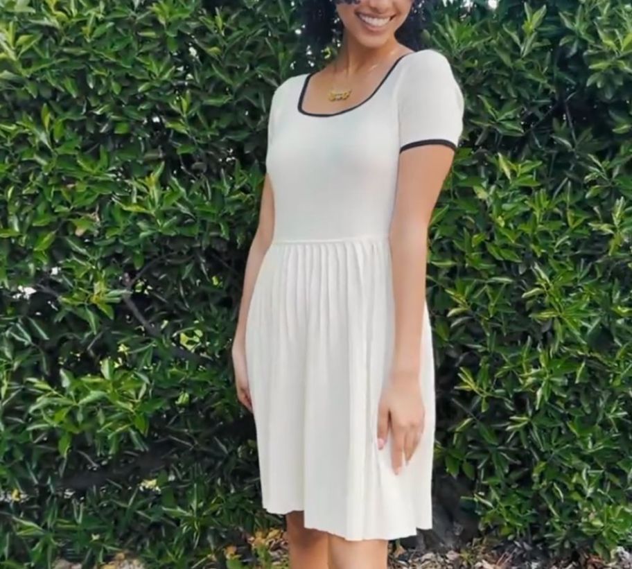 A woman wearing a pleated, white dress