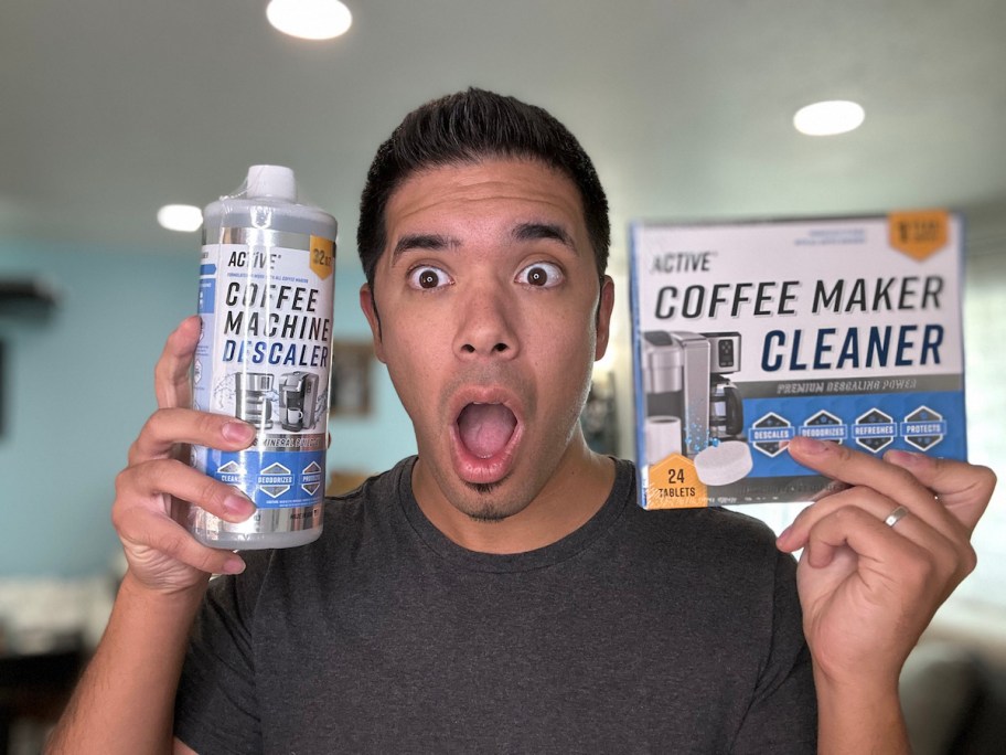 man holding up bottle and box of active coffeemaker cleaner