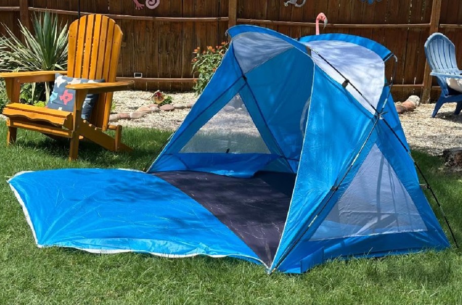Blue amazon tent on a grassy backyard opened up next to a chair