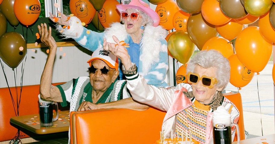 two woman and man with root beer floats and balloons 