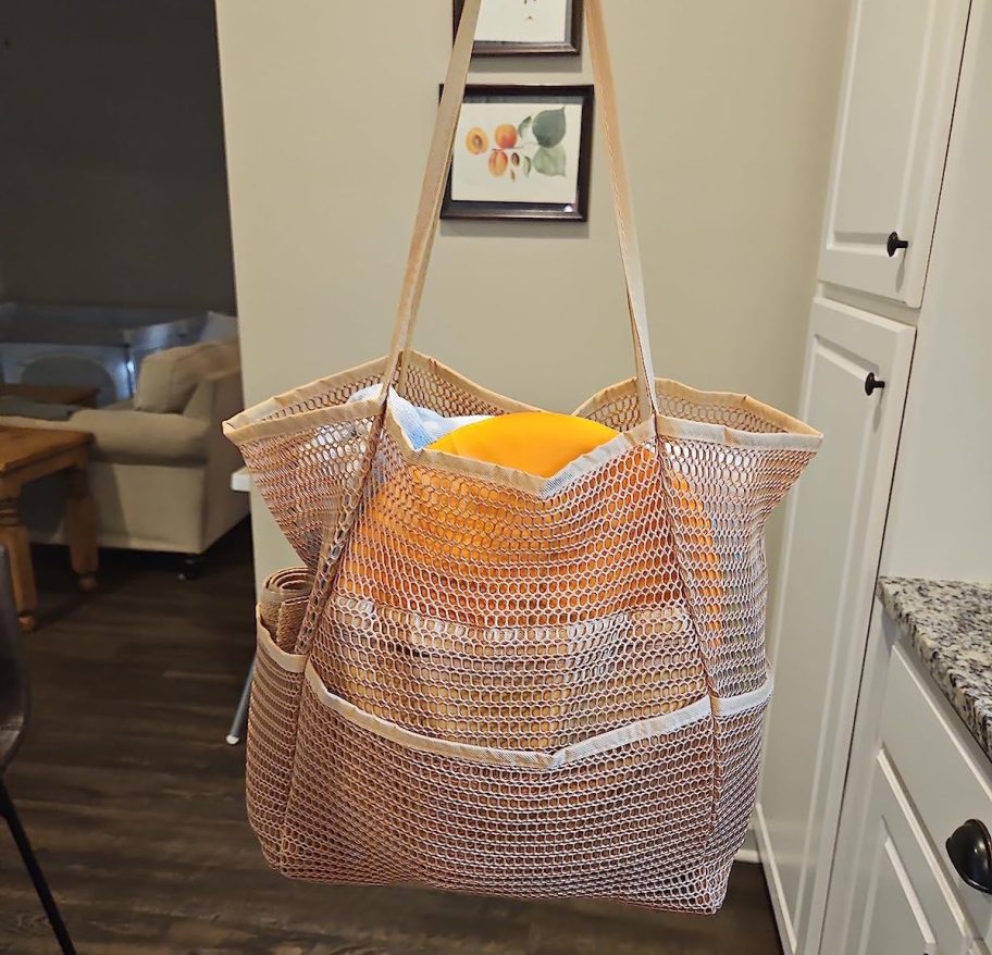 mesh beach tote bag with towel and frisbee inside