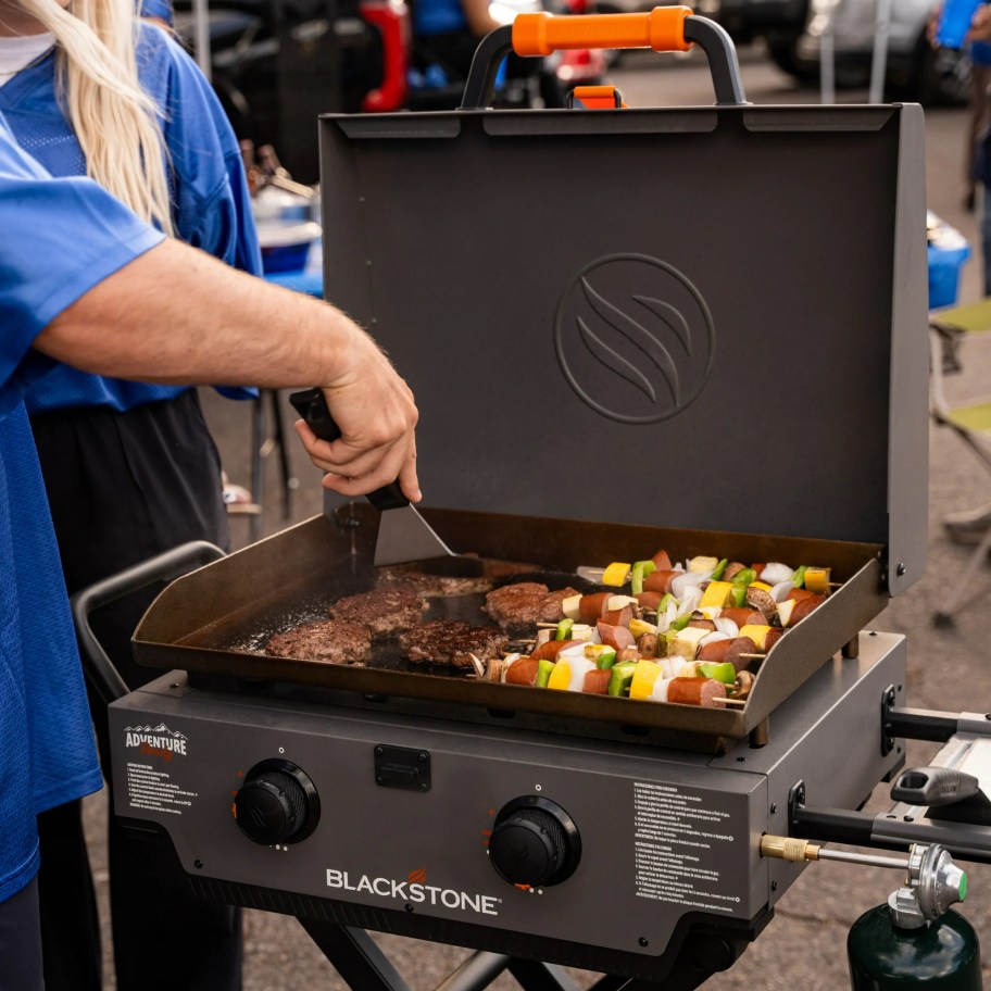 person grilling food on blackstone grill