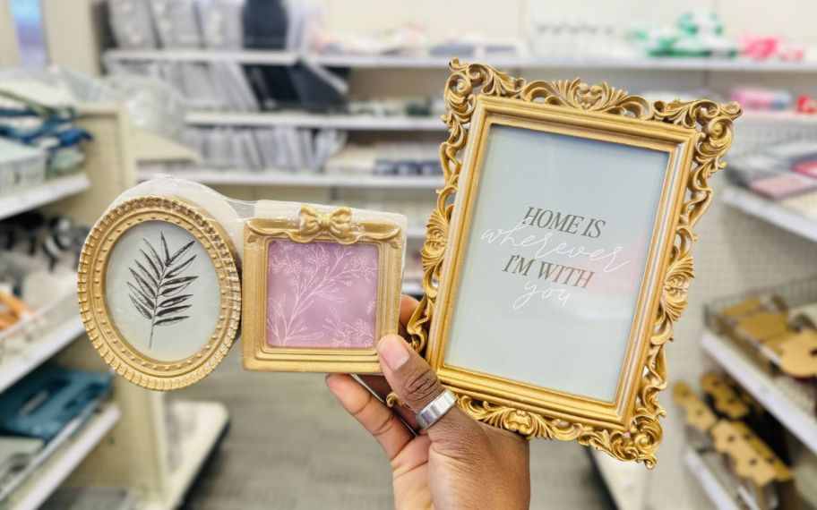 womans hand holding two picture frames