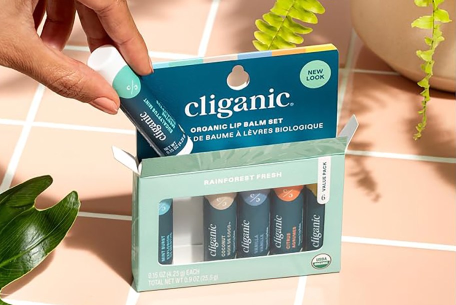 person pulling lip balm out of cliganic lip balm box set